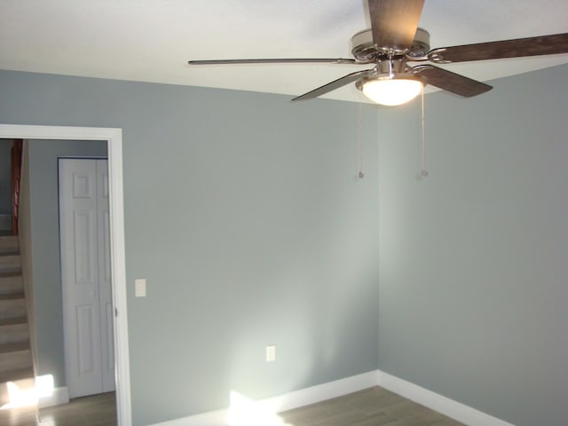 unfurnished room with stairway, baseboards, and wood finished floors