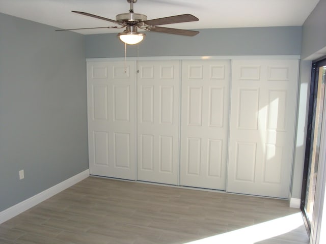 unfurnished bedroom with a ceiling fan, light wood-style flooring, baseboards, and a closet