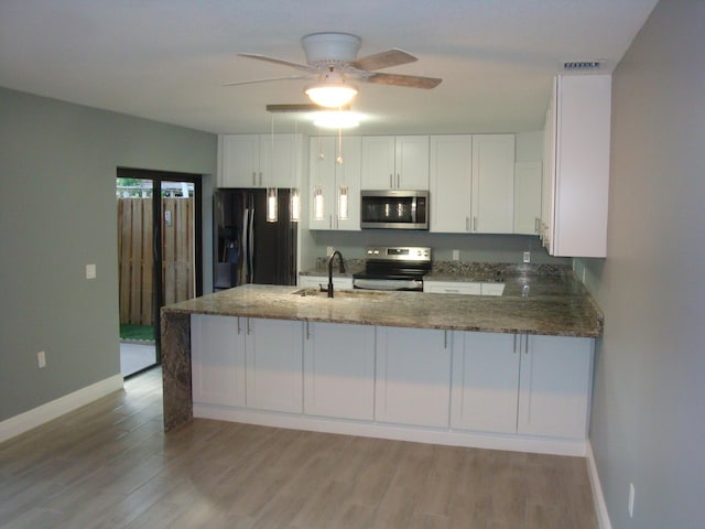 kitchen with stainless steel appliances, white cabinets, visible vents, and dark stone countertops