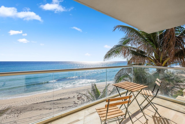 balcony featuring a water view and a beach view