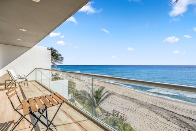 balcony featuring a view of the beach and a water view