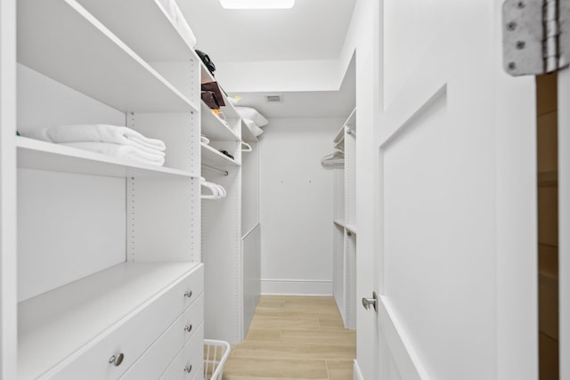 spacious closet featuring visible vents and light wood-type flooring