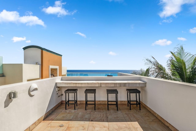 view of patio featuring a water view and outdoor dry bar