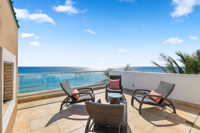 view of patio with a beach view, a balcony, and a water view