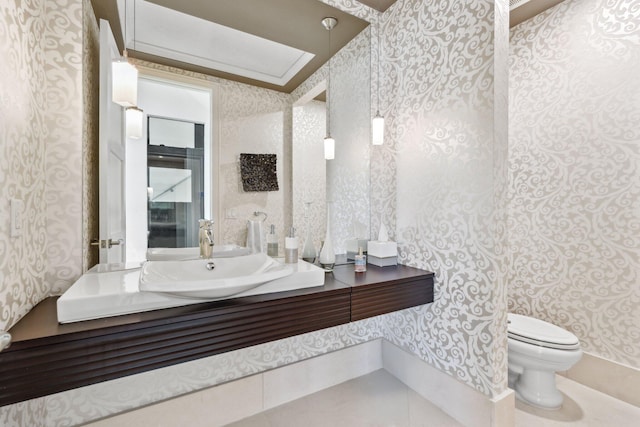 bathroom with wallpapered walls, toilet, and vanity