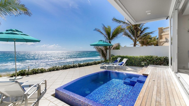 view of pool featuring a patio area, fence, and a water view