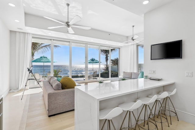 kitchen with a kitchen breakfast bar, recessed lighting, light wood-type flooring, and ceiling fan