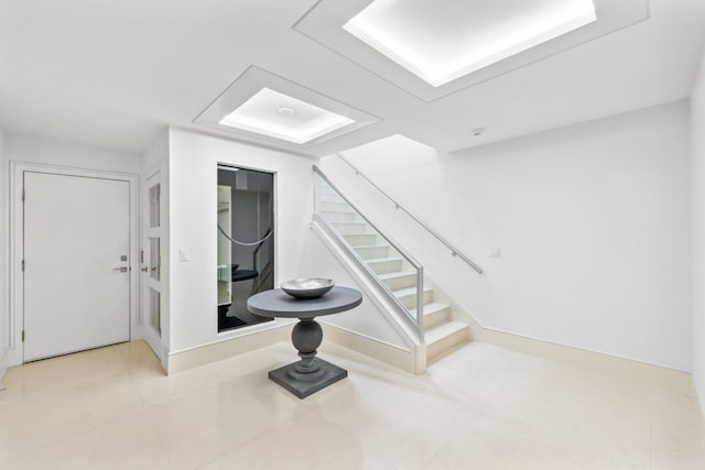 interior space with tile patterned flooring, stairway, and baseboards