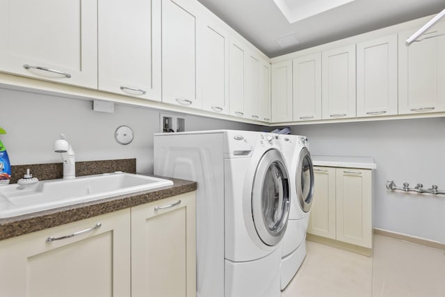 washroom with independent washer and dryer, a sink, cabinet space, light tile patterned floors, and baseboards