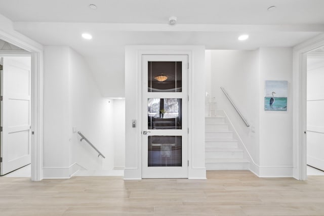 unfurnished living room with light wood finished floors, recessed lighting, and baseboards