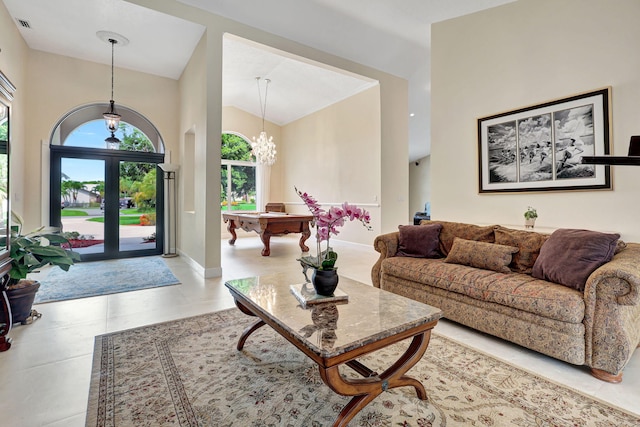 interior space featuring high vaulted ceiling, an inviting chandelier, visible vents, and baseboards