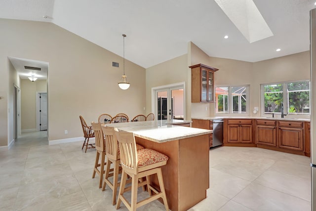 kitchen featuring french doors, brown cabinets, a breakfast bar area, light countertops, and glass insert cabinets