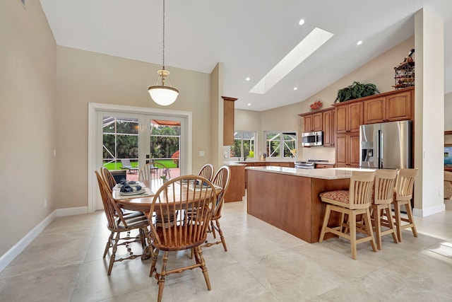 kitchen with stainless steel appliances, a skylight, light countertops, french doors, and brown cabinetry