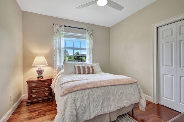 bedroom featuring a ceiling fan, baseboards, and wood finished floors