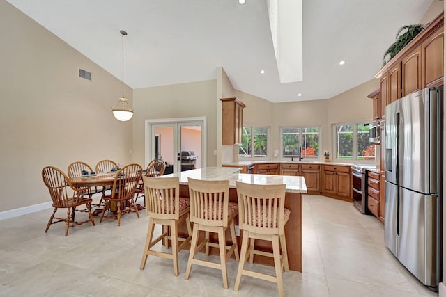 kitchen with french doors, stainless steel appliances, visible vents, a peninsula, and a kitchen bar