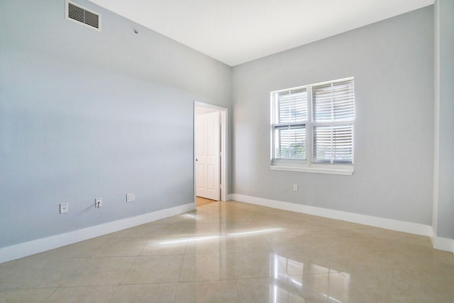 tiled spare room with visible vents and baseboards