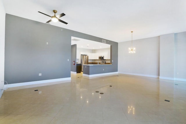 unfurnished living room featuring visible vents, baseboards, and ceiling fan with notable chandelier