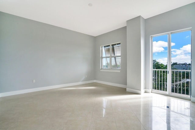 unfurnished room with light tile patterned floors and baseboards