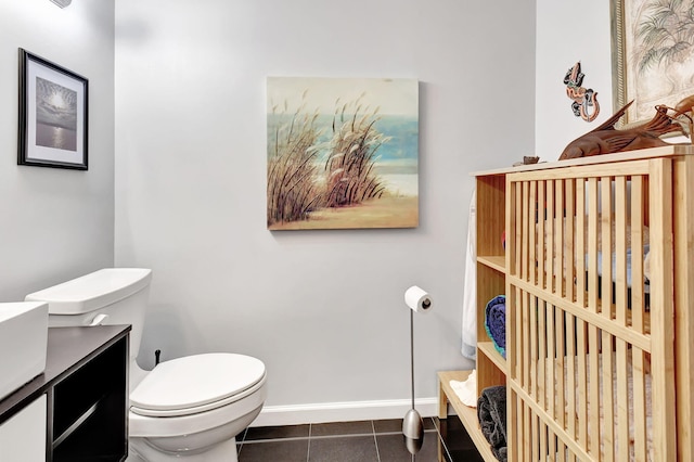 bathroom featuring toilet, tile patterned flooring, baseboards, and vanity