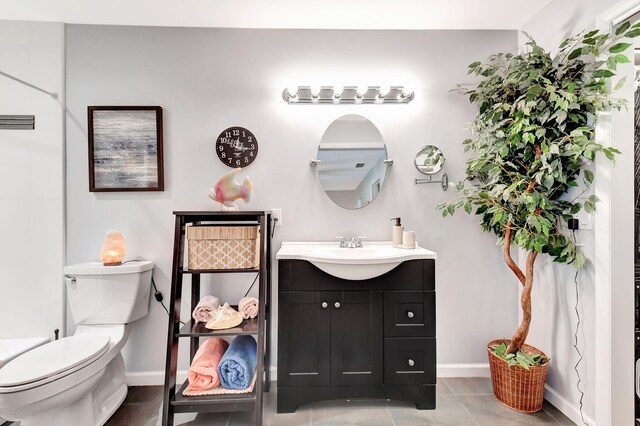 bathroom with tile patterned flooring, vanity, toilet, and baseboards