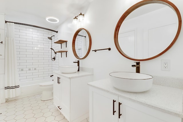 bathroom featuring toilet, two vanities, shower / bath combo, and a sink