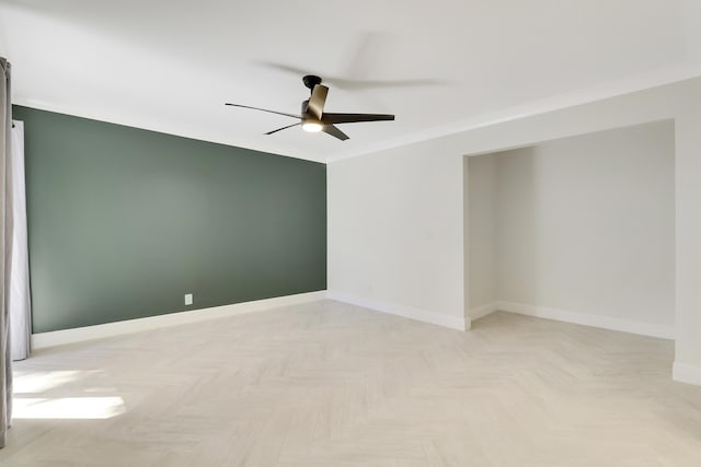 spare room with baseboards, a ceiling fan, and crown molding