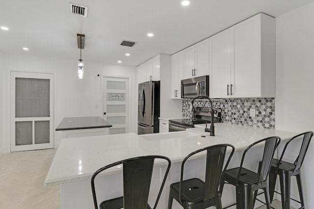 kitchen with visible vents, tasteful backsplash, a kitchen island, and appliances with stainless steel finishes