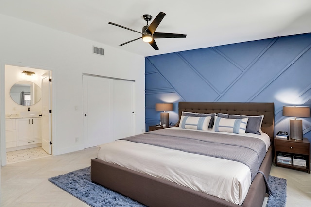 bedroom featuring visible vents, ceiling fan, a sink, a closet, and ensuite bathroom