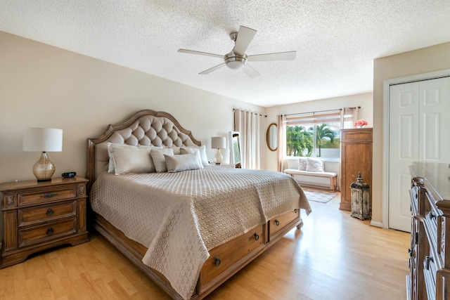 bedroom with a ceiling fan, a textured ceiling, and light wood finished floors