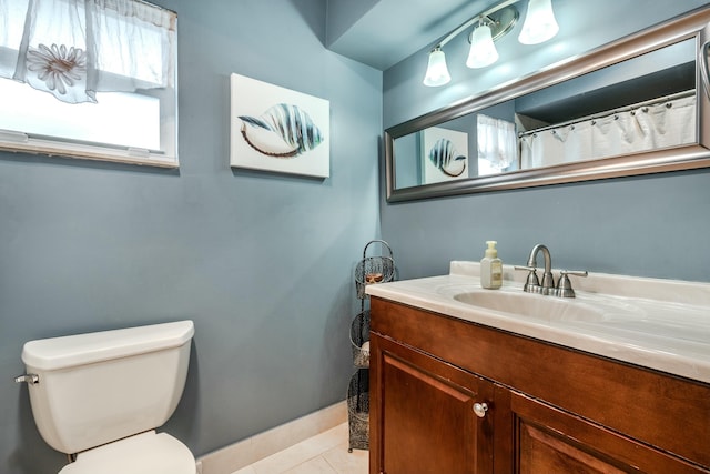 bathroom with baseboards, vanity, toilet, and tile patterned floors