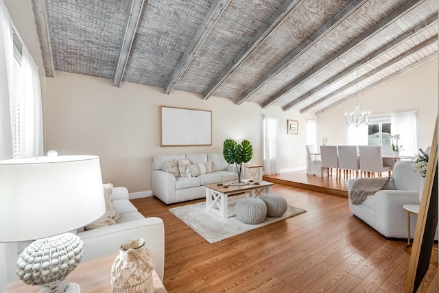 living room featuring baseboards, vaulted ceiling with beams, wood-type flooring, and an inviting chandelier