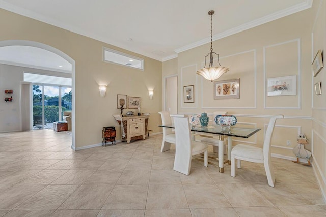 dining room with arched walkways, crown molding, baseboards, and light tile patterned floors