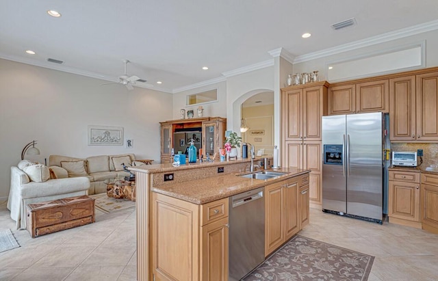 kitchen featuring visible vents, appliances with stainless steel finishes, arched walkways, and a sink