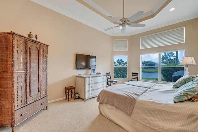 bedroom with a tray ceiling, crown molding, light colored carpet, ceiling fan, and baseboards