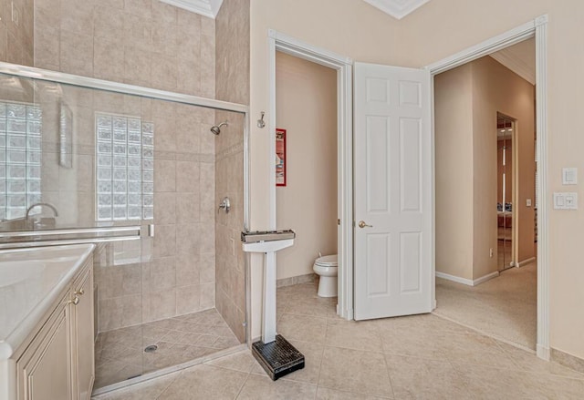 full bathroom featuring ornamental molding, a stall shower, and toilet