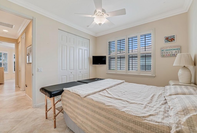 bedroom with light tile patterned flooring, visible vents, baseboards, a closet, and crown molding