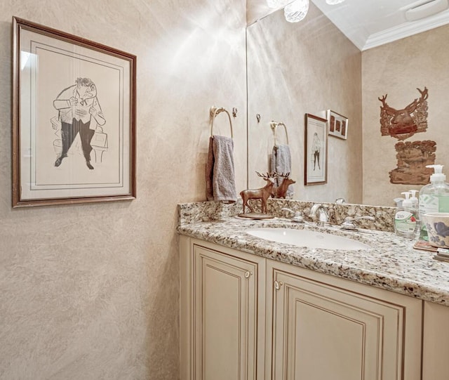 bathroom with ornamental molding and vanity