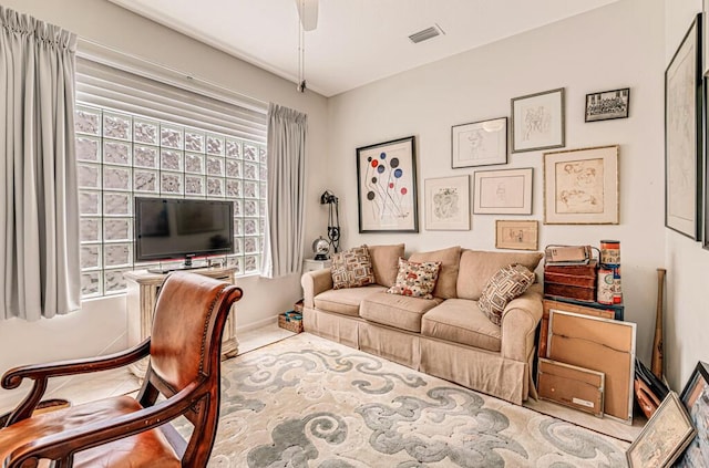 living room with a ceiling fan, a healthy amount of sunlight, and visible vents