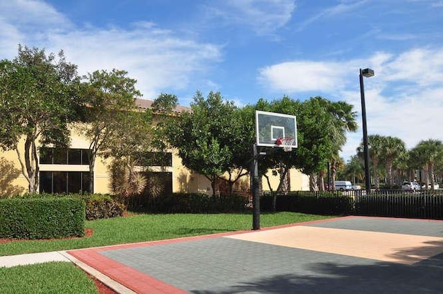 view of basketball court with community basketball court, fence, and a yard