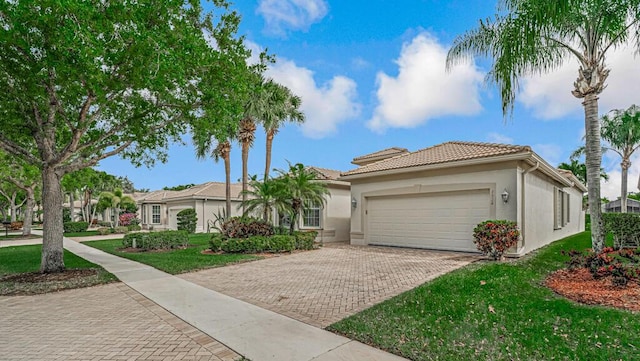 view of front facade with an attached garage, a tiled roof, decorative driveway, stucco siding, and a front yard