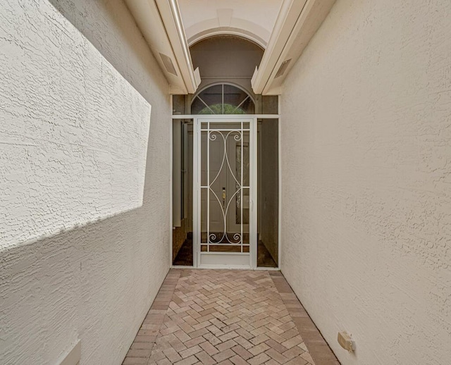 doorway to property featuring stucco siding