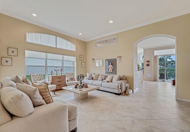 living area with arched walkways, light tile patterned floors, recessed lighting, ornamental molding, and baseboards