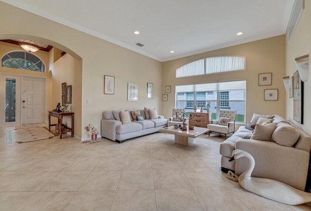 living room with light tile patterned floors, a high ceiling, arched walkways, and ornamental molding