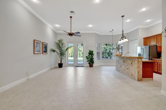 kitchen with french doors, crown molding, visible vents, stainless steel fridge, and baseboards