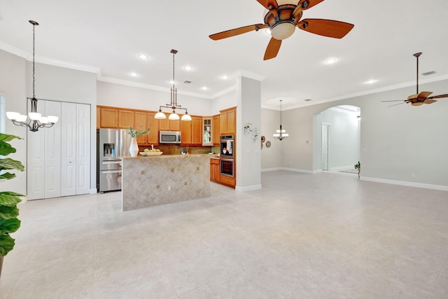 kitchen featuring arched walkways, baseboards, open floor plan, appliances with stainless steel finishes, and backsplash