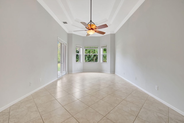 spare room featuring ceiling fan, light tile patterned floors, baseboards, ornamental molding, and a tray ceiling