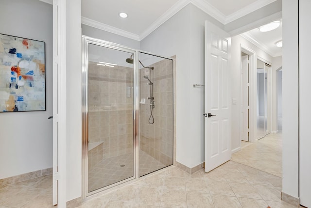 full bath with a stall shower, tile patterned flooring, crown molding, and baseboards