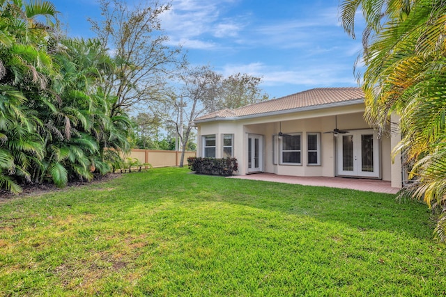 back of house featuring a lawn, ceiling fan, fence, french doors, and a patio area