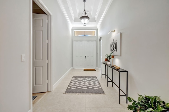 doorway to outside featuring arched walkways, crown molding, light tile patterned floors, a raised ceiling, and baseboards