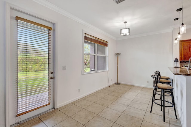 kitchen featuring light tile patterned floors, ornamental molding, and plenty of natural light